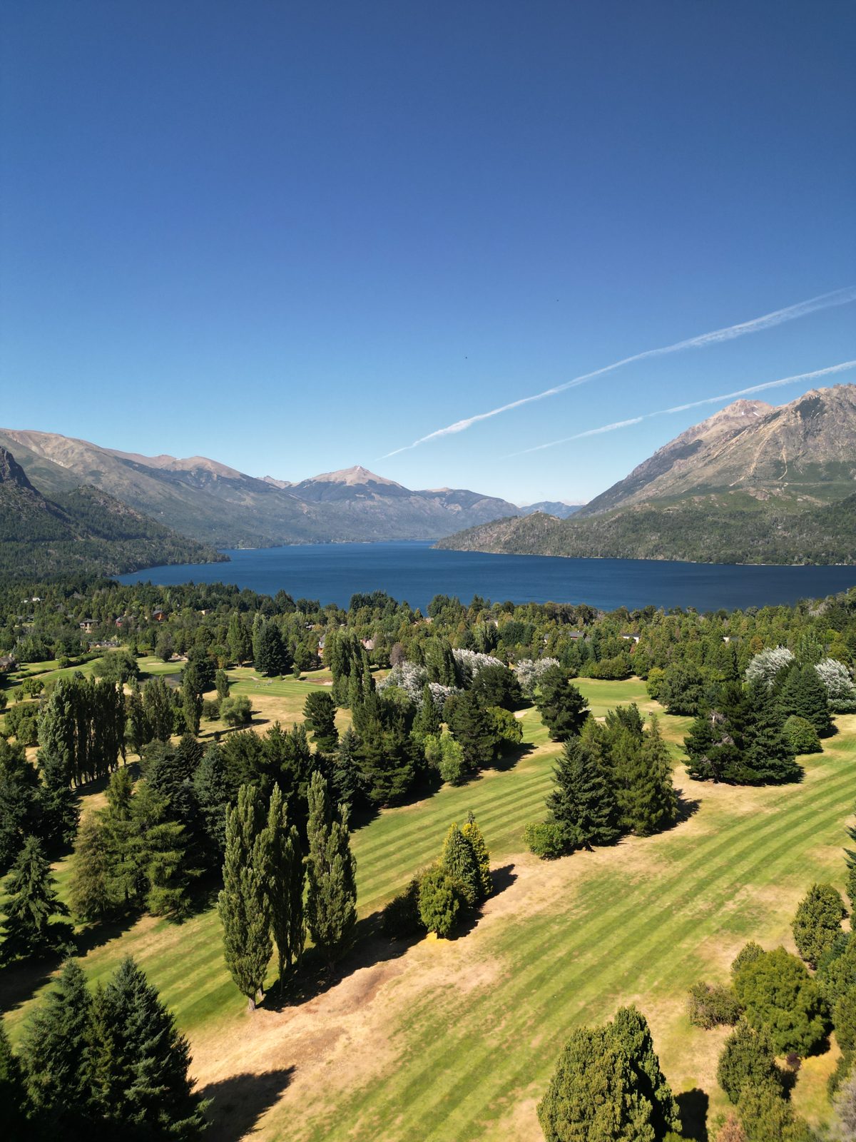 Cancha de golf de Arelauquen con el lago Nahuel Huapi y la cordillera de fondo