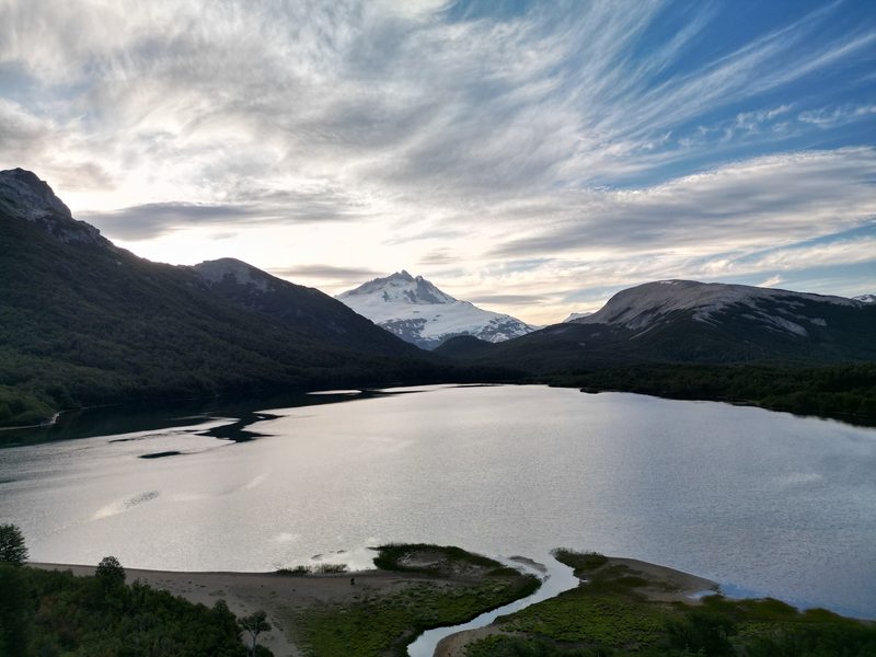 Laguna escondida al pie de la cordillera con un cerro nevado de fondo