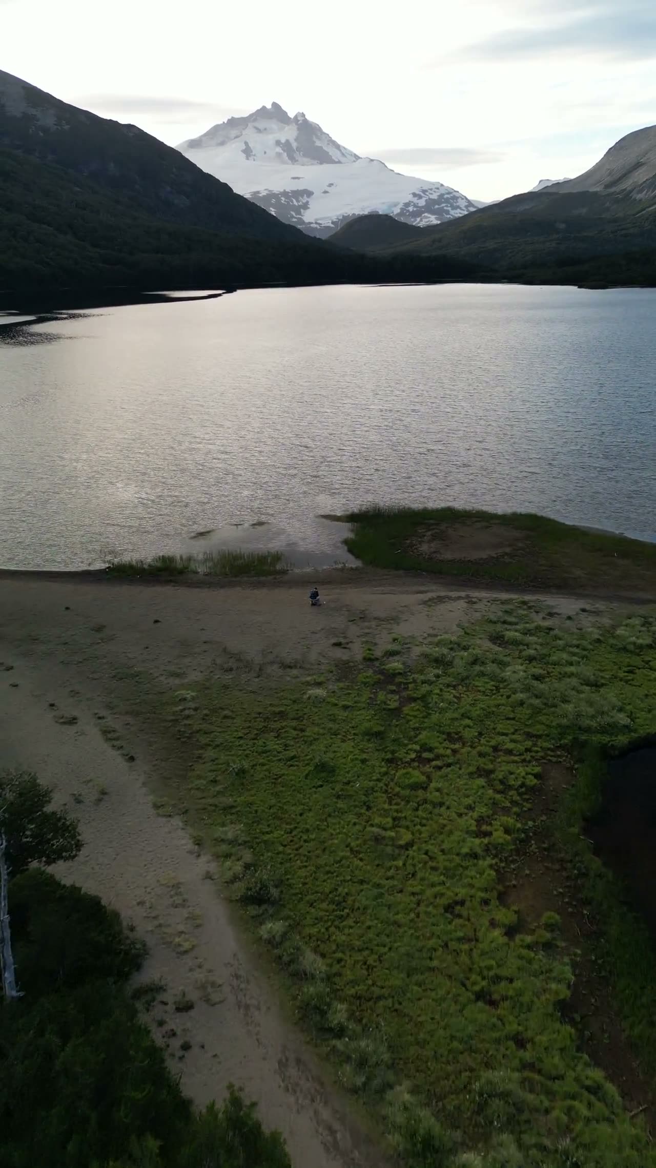 Laguna escondida con un cerro nevado de fondo, filmada desde el dron
